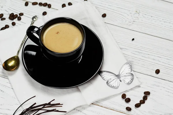 Café con leche en una taza negra sobre fondo blanco —  Fotos de Stock