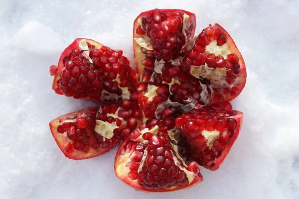 Ripe pomegranate fruit on snowy background.selective focus. closeup — Stock Photo, Image