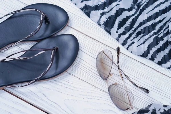 Zapatillas de verano para mujer, bufanda y gafas de sol con estampado de cebra sobre fondo blanco de madera — Foto de Stock