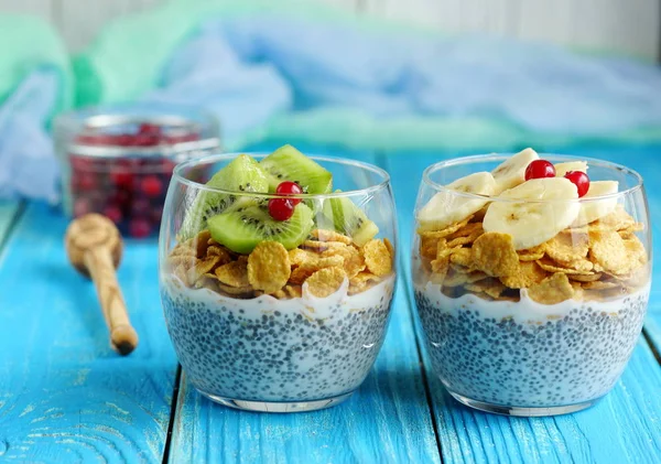 Budín de chía con copos de maíz y frutas sobre fondo de madera azul — Foto de Stock