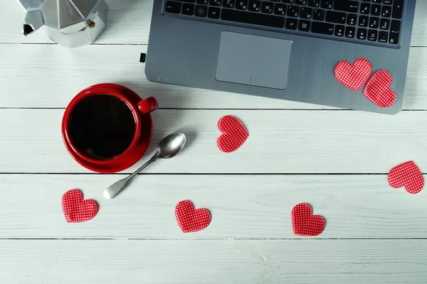 workplace for computer, coffee in a red cup and hearts.flat lay