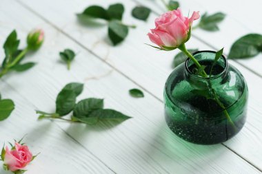  Beyaz ahşap zemin üzerinde Güllü çiçekli natürmort. Kadınlar Günü. 8 Mart