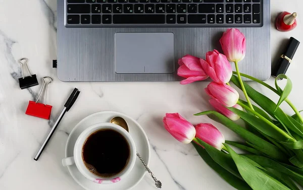 Плоский лежал, офисный стол с видом сверху. рабочая зона с ноутбуком, чашкой кофе и букетом розового тюльпана . — стоковое фото