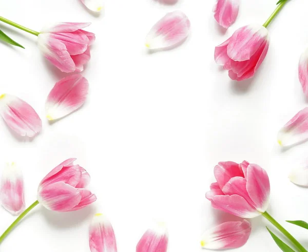 Modello floreale realizzato con tulipani rosa su sfondo bianco. Posa piatta, vista dall'alto. Schema di fiori. Struttura del motivo floreale. cornice — Foto Stock