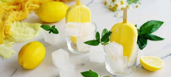 Verfrissend citroen ijs in glas kopjes op een lichte marmeren tafel. Zomer voedsel concept. Banner. — Stockfoto