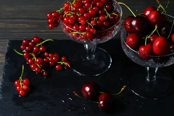 Bayas frescas de cereza dulce y grosella roja sobre un fondo oscuro. Llave baja.Vintage. Copiar espacio — Foto de Stock