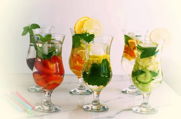 Bebidas refrescantes saludables de verano hechas de frutas frescas en surtido sobre un fondo blanco — Foto de Stock
