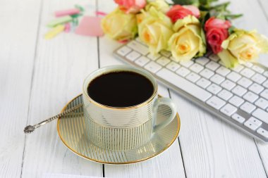 dizüstü bilgisayar, fincan kahve ve güller