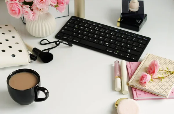 Accesorios de maquillaje femenino, taza de cofee y ramo de rosas rosadas sobre fondo blanco. Piso laico, vista superior escritorio femenino, espacio de trabajo con portátil . — Foto de Stock