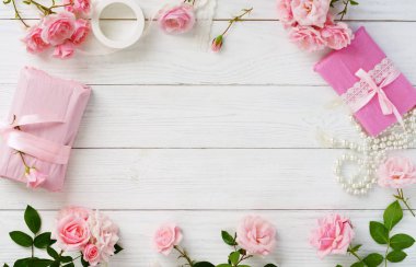 Güzel pembe Gül ve hediye Beyaz ahşap arka plan üzerinde ambalaj Pembe buket. Üstten Görünüm. Kopya alanı