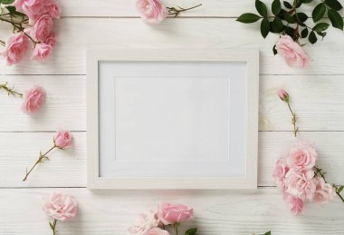 Poster çerçeve mockup, üstten görünüm, pembe Gül Beyaz ahşap zemin üzerinde. Tatil kavramı. Düz yatıyordu. Kopya alanı