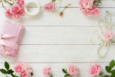 Güzel pembe Gül ve hediye Beyaz ahşap arka plan üzerinde ambalaj Pembe buket. Üstten Görünüm. Kopya alanı