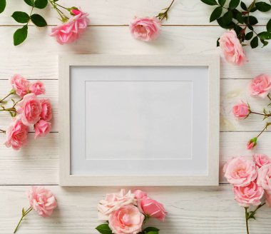 Poster çerçeve mockup, üstten görünüm, pembe Gül Beyaz ahşap zemin üzerinde. Tatil kavramı. Düz yatıyordu. Kopya alanı