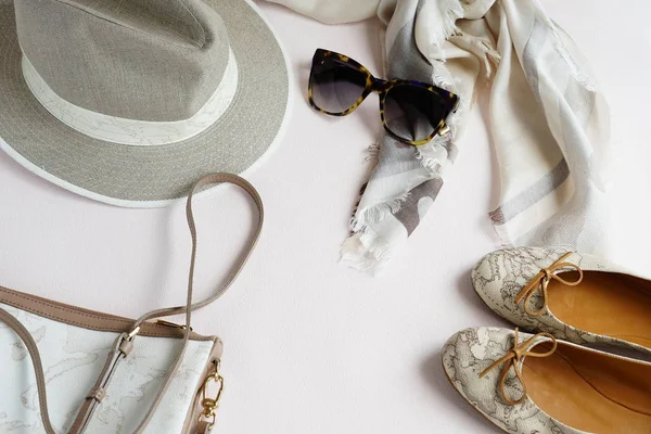 Flat lay conjunto de roupas femininas de luxo e acessórios em cachecol cores pastel, saco, escunas, chapéu e óculos de sol sobre fundo claro. vista superior — Fotografia de Stock