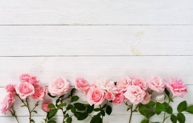 Beyaz ahşap zemin üzerinde güzel pembe gül buketi. Üstten Görünüm. Kopya alanı.
