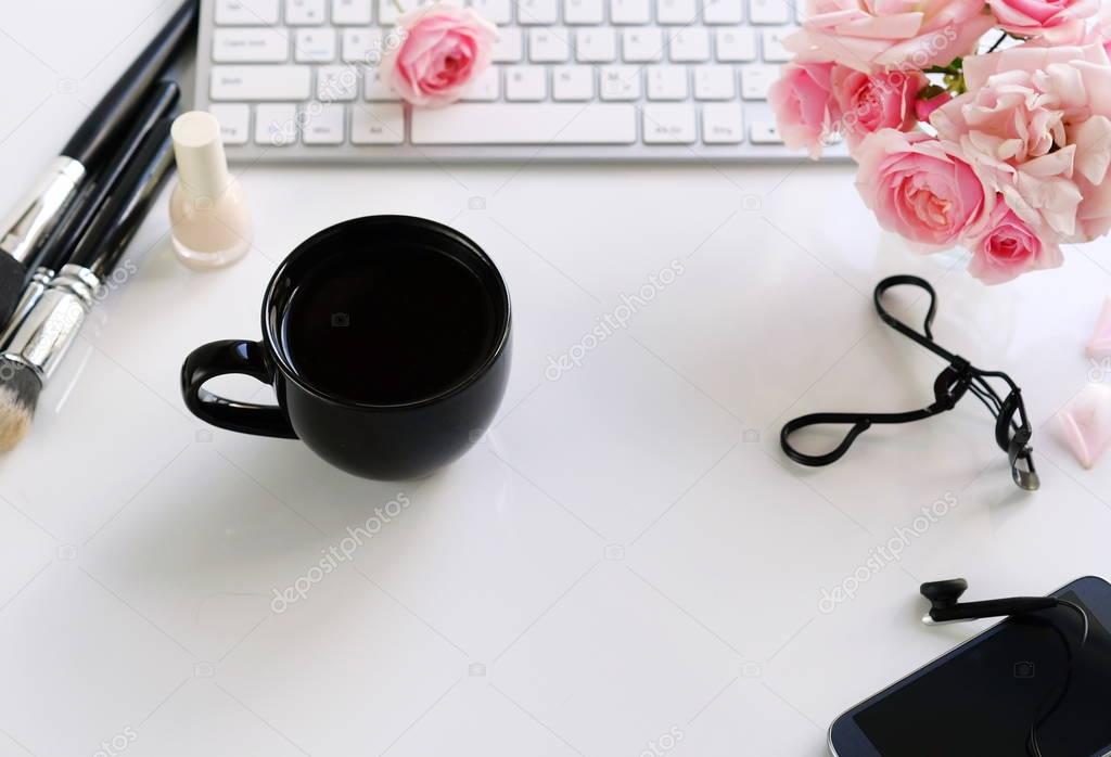 Flat lay, top view office feminine desk, female make up accessories, workspace with laptop, phone, cup of coffee and bouquet roses.Beauty blog concept.Copy space