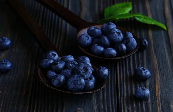 Bleuets mûrs sur un fond de bois foncé. Clé basse. — Photo