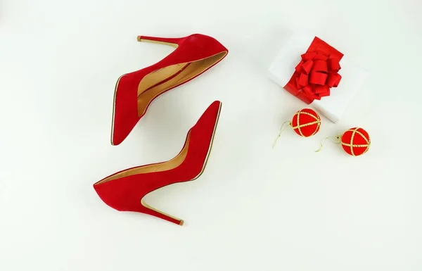 Zapatos de tacón rojo con estilo femenino de moda, regalo de Navidad, bolas de Navidad sobre fondo blanco — Foto de Stock