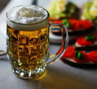 light bira köpük ve sandviç gri bir tablo ile bir bardak
