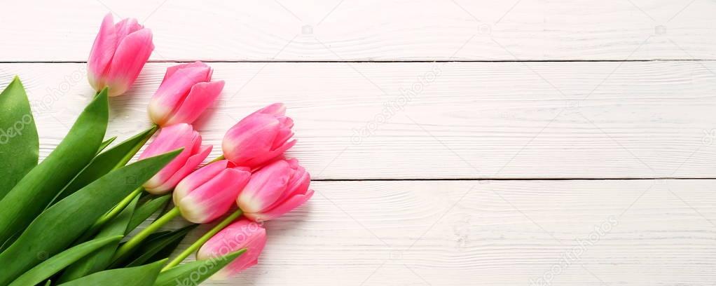 a bouquet of pink tulips on a white wooden background. top view. copy space. Holiday concept.