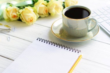 ofis tablo kadınsı Masası. dizüstü bilgisayar, fincan kahve ve buket Sarı Gül ile çalışma alanı. Tatil kavramı.