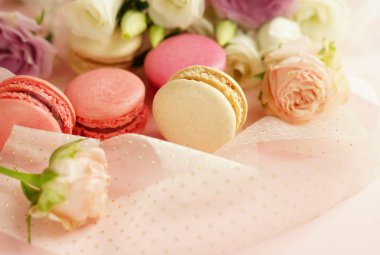 macaroons ile çiçekler soluk pembe bir arka plan üzerinde pastel renklerde. Tatil background.copy alanı