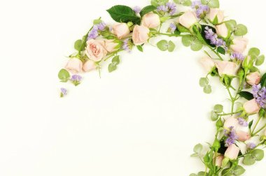 Çiçekler arka plan. Pembe ve mor çiçekler ve okaliptüs dalları beyaz bir arka plan üzerinde çelenk çerçeve yaptı. Düz yatıyordu. Üstten Görünüm. kopya alanı