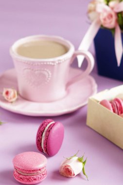 Pastel renkler ve soluk mor zemin üzerine sütlü kahve macaroons