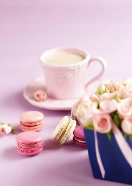 Buket pembe Gül çiçek ve kahve bir soluk mor zemin üzerine pastel renklerde macaroons