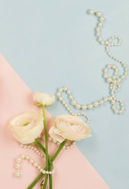 Pembe tipik çiçekler ve mavi soluk pembe renkli inci kolye. Üstten Görünüm. Kopya alanı