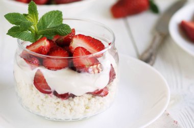 lezzetli ve sağlıklı bir kahvaltı süzme peynir yoğurt ve Beyaz ahşap zemin üzerinde taze çilek ile