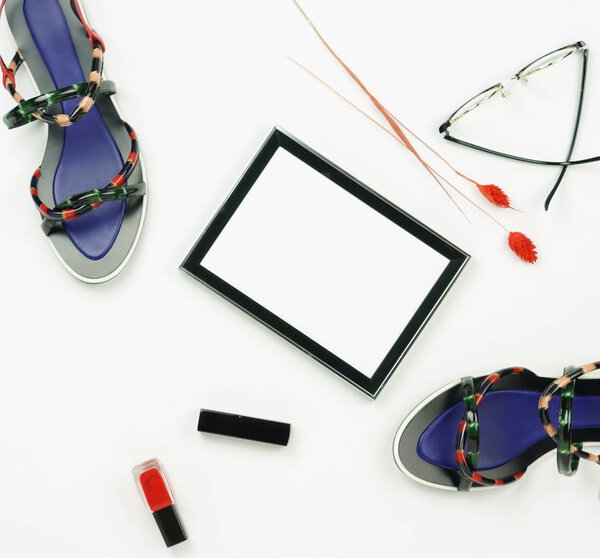 Female fashionable stylish accessories and cosmetics. Female stylish summer sandale shoes,frame,  lipstick ,glasses,  red nail polish on a white background. Beauty blog concept.Flat lay.Top view. Copy space