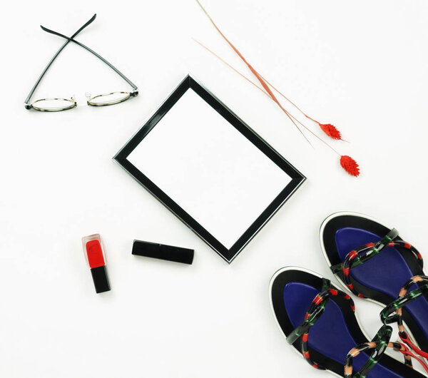 Female fashionable stylish accessories and cosmetics. Female stylish summer sandale shoes,frame,  lipstick ,glasses,  red nail polish on a white background. Beauty blog concept.Flat lay.Top view. Copy space