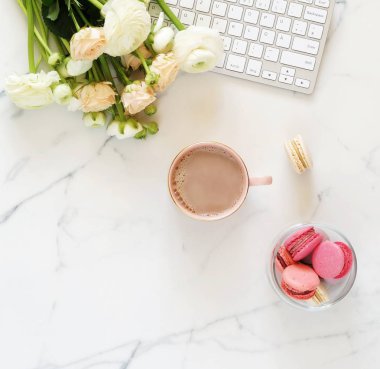 Düz yatıyordu, en iyi görünüm ev ofis tablo kadınsı Resepsiyon. laptop, fincan kakao, macaroons ve güzel buket pembe ve beyaz çiçekler ile çalışma alanı. Kopya alanı