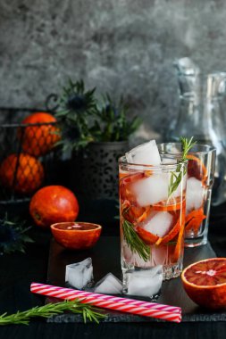 Kırmızı kan portakal, buz ve biberiye koyu arka plan üzerinde kokteyl serinletici su, detoks.
