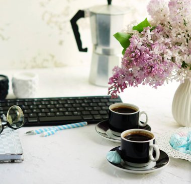 Ev ofis büro. klavye, bardak kahve, defter, gözlük ve beyaz arka plan üzerinde bir vazoda Eflatun çiçekler buket ile kadın çalışma alanı. Kopya alanı