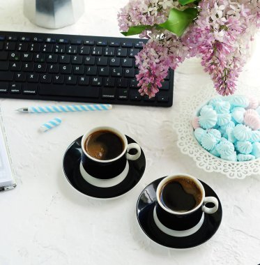 Ev ofis büro. klavye, bardak kahve, defter, gözlük ve beyaz arka plan üzerinde bir vazoda Eflatun çiçekler buket ile kadın çalışma alanı. Uzay kopyalayın. Üstten Görünüm