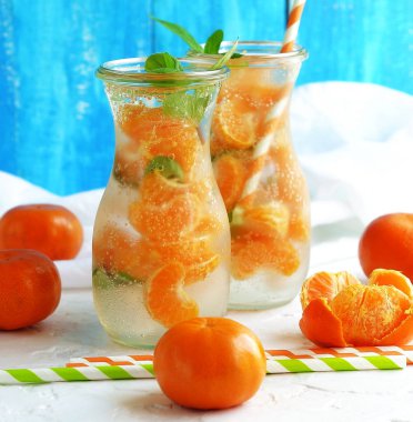 Kokteyl serinletici narenciye mandarine nane ile cam meyve, beyaz zemin üzerine su Detoks