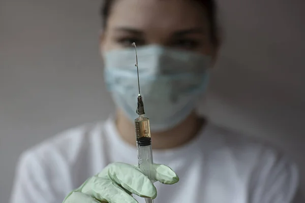 Hemşire elinde şırınga tutuyor..