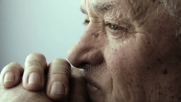 Thoughtful old man portrait: lateral portrait with window light — Stock Video