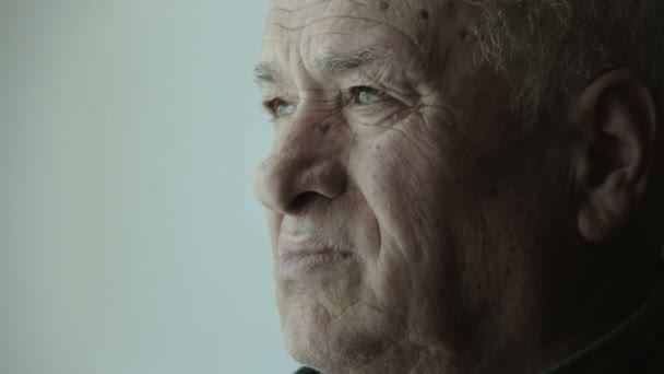 Pensive old man drinking a cup of coffee or tea — Stock Video