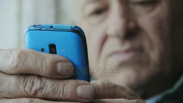 Anciano escribiendo en la pantalla táctil de un smartphone: teléfono móvil, celular — Vídeos de Stock