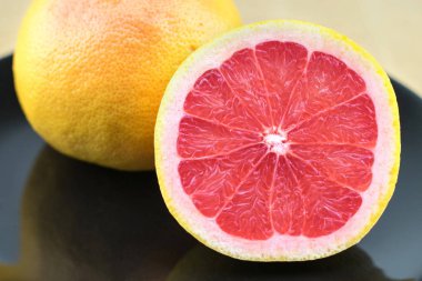 Siyah plaka üzerinde taze kırmızı greyfurt.