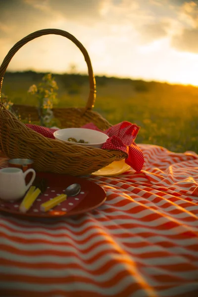 Spring picnic basket on sunset — Stock Photo, Image