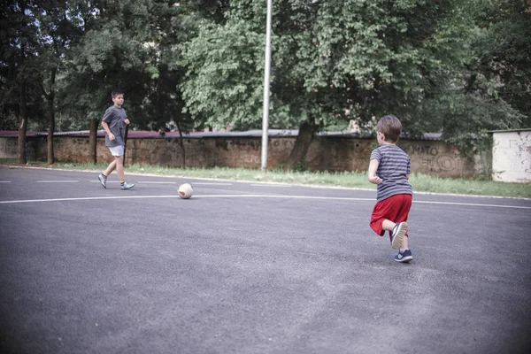 Dois irmãos jogando futebol — Fotografia de Stock