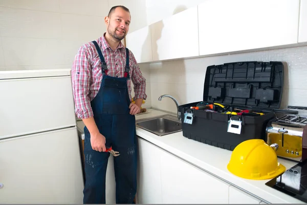 英俊的男子站在厨房与他的工具箱 — 图库照片