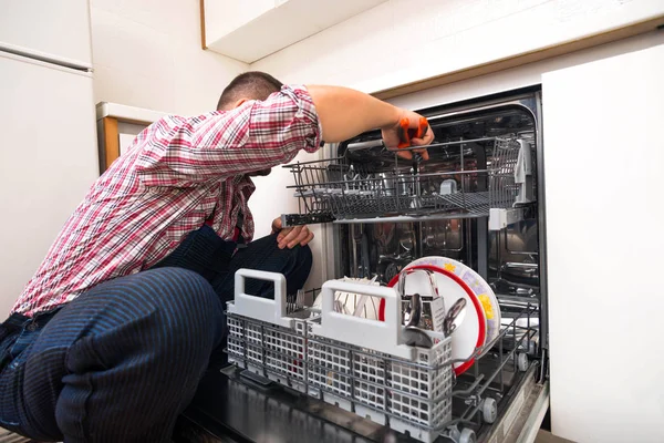 厨房里的修理工修理洗碗机 — 图库照片