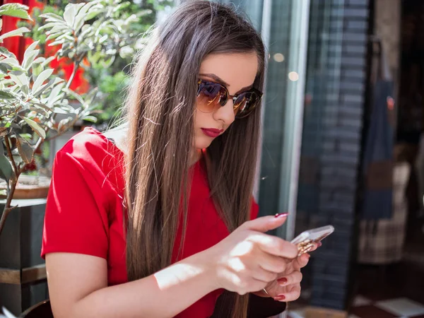 Mädchen benutzt ihr Handy an einem sonnigen Tag — Stockfoto