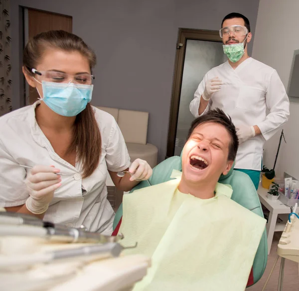 口腔衛生医療コンセプトで医院でチェックをやっている歯科医で完璧な歯を持つ少年 — ストック写真