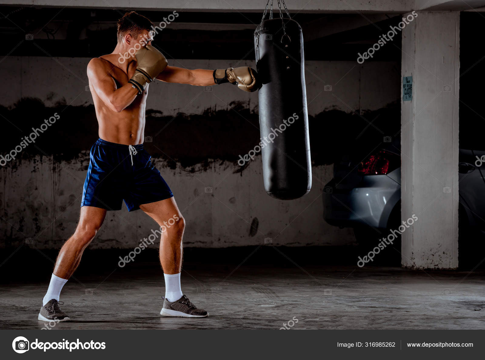 Boxer throws punches in the gym while training — Stock Photo ©